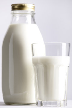 Glass and Bottle of fresh milk,  focus on the glass.