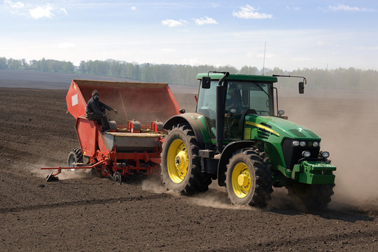 Tractor with seeding-machine on potato field