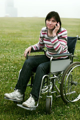 Fototapeta premium Woman in wheelchair talking by phone
