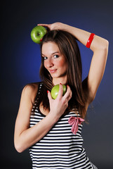 Smiling woman with two green apples