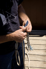 A sailor curing cables, using a sailor’s hand knife