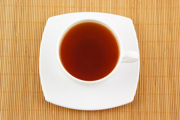 White cup of tea on wooden background
