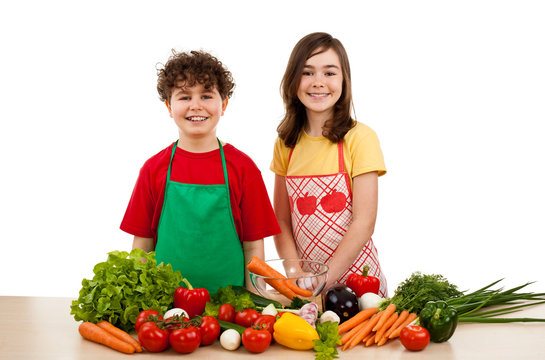Healthy eating - kids and fresh vegetables isolated on white