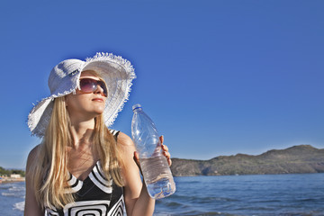 Fototapeta na wymiar Young blond woman with bottle of water