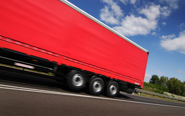 Red truck, lorry driving on country-road