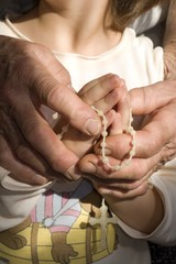 hands of grandmother and grandchild by the prayer
