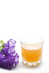 Glass of orange juice with bellflowers