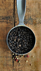 Black Peppercorns in a Metal Measuring Cup