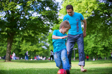 Obraz premium The man and the boy play football.