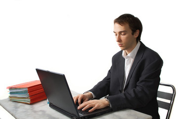 Young man works on laptop, side view