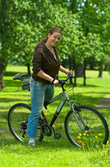 Obraz premium Woman bicyclist on the bike in park