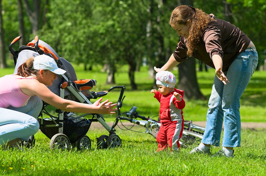 Mother And Babysitter Learn Child To Do First Steps.