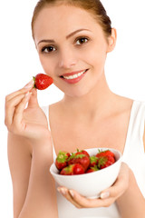 Woman holding bowl of strawberries, smiling