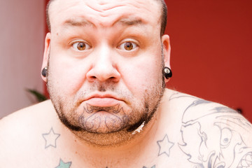 portrait of a man with tattoos making faces