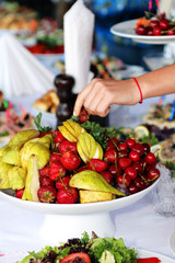 Vase with fruits on served table