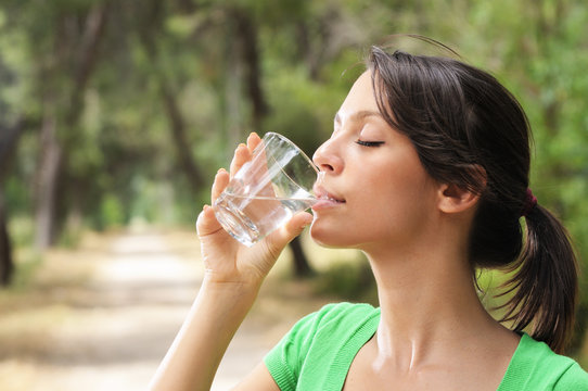 young woman water drinking in glass