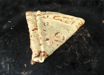 Crepe in a black pan made by a Paris street vendor