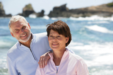 Portrait d'un couple de seniors souriants au bord de la plage