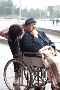 man in an invalid carriage and his wife on walk
