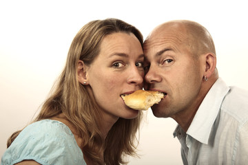 Man and woman eating a roll