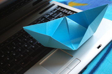 Paper boat sailing on laptop