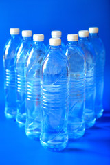 Mineral water bottle isolated on blue background, close up