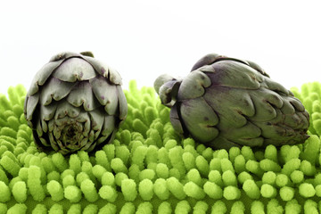 Miniartischocken auf neongruenem Kissen