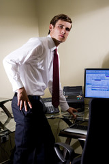 Portrait of serious young businessman standing at his desk
