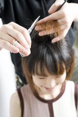 美容師に前髪を切られる日本人女性