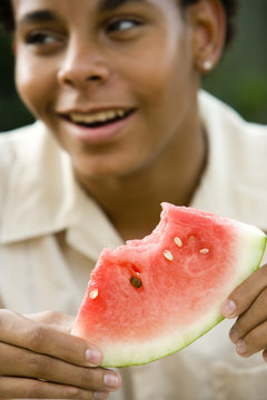 African American teenage boy enjoying slice of watermelon