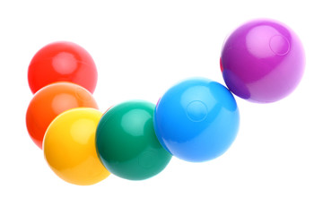 Six shiny coloured plastic toy balls in row isolated on white