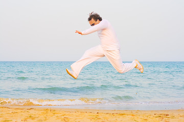 Man in white running on a beach