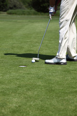 Obraz premium golfspieler mit putter, putting golfball