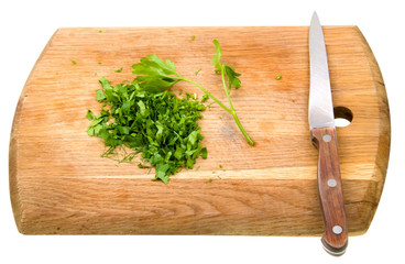 Cutting board with green chopped herbs isolated on white