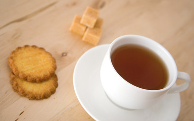 Cup of black tea, sugar and biscuits