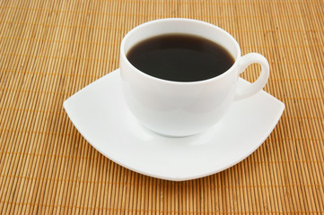 White cup of coffee on wooden background