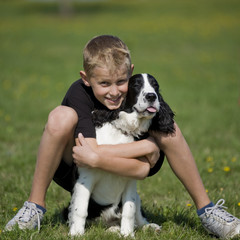 Naklejka na ściany i meble A boy poses with his puppy