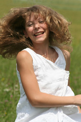 Lachendes Mädchen tanzt auf Sommerwiese