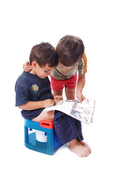 Two cute kids looking at body building pictures