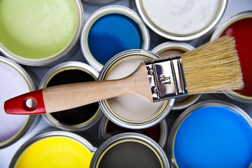 Cans and paint and brushes on the Colorful background