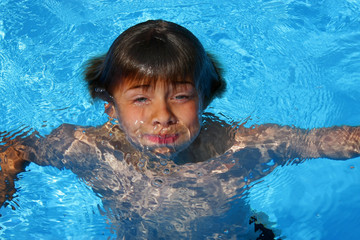 Fototapeta na wymiar auftauchender Junge im Swimming Pool