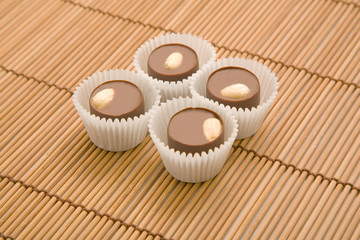 four chocolate sweets on bamboo mat