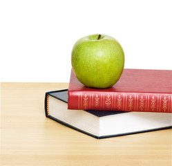 Green apple on books on desk