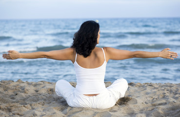 Fototapeta na wymiar Woman making yoga exercise on the beach