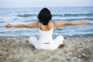 Fototapeta na wymiar Woman making yoga exercise on the beach