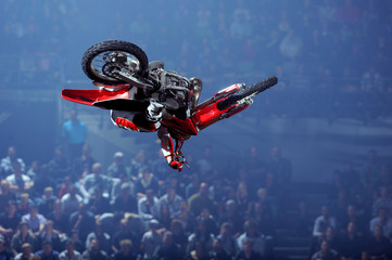 A freestyle moto cross rider performs a trick
