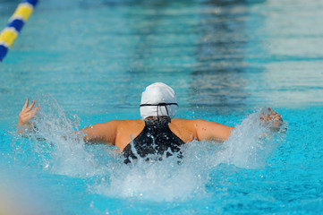 A female butterfly swimmer in action during a race.