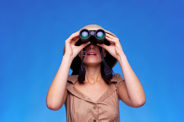 Woman in safari hat looking through binoculars