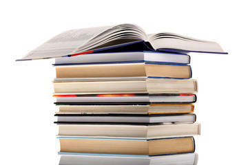 Open dictionary on top of book stack isolated on white