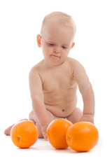 Portrait of adorable baby boy playing with three oranges